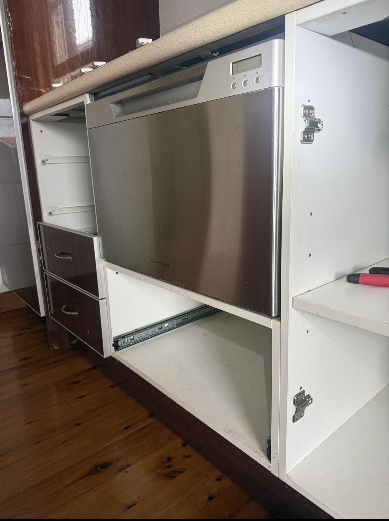 Dishwasher drawer installed into cabinetry with hose runners fitted by Ready Plumbing