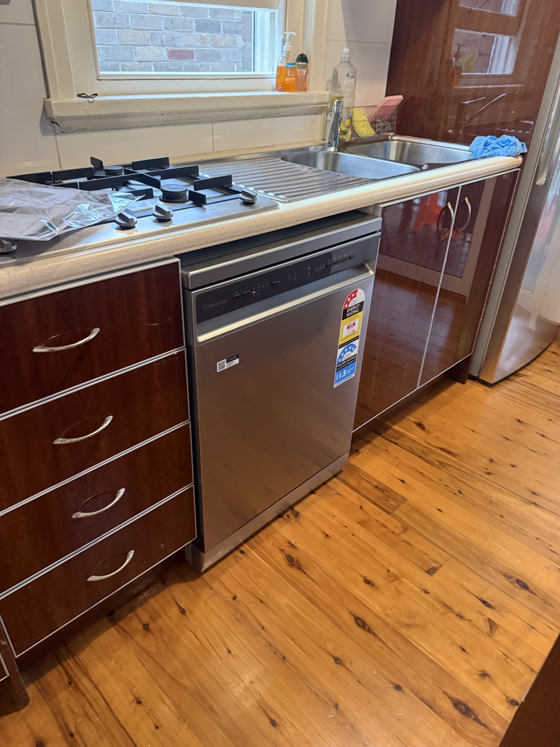 New dishwasher installed and connected under the kitchen counter by Ready Plumbing