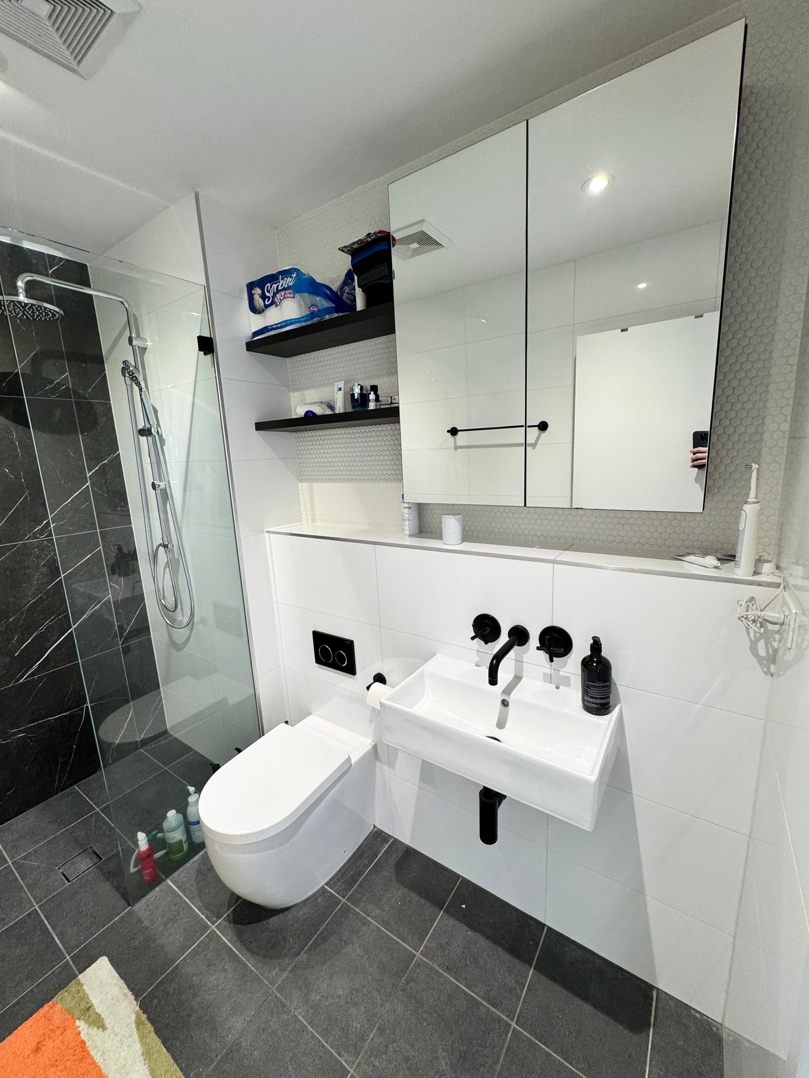 The old wall-hung basin bowl and matte black tapware, with no bench space or storage